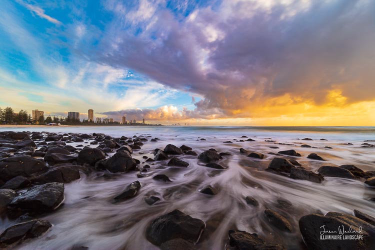 The sun rises through stormy clouds as the water swirls through the rocks. Burleigh Heads, Gold Coast, Queensland, Australia - landscape photographer