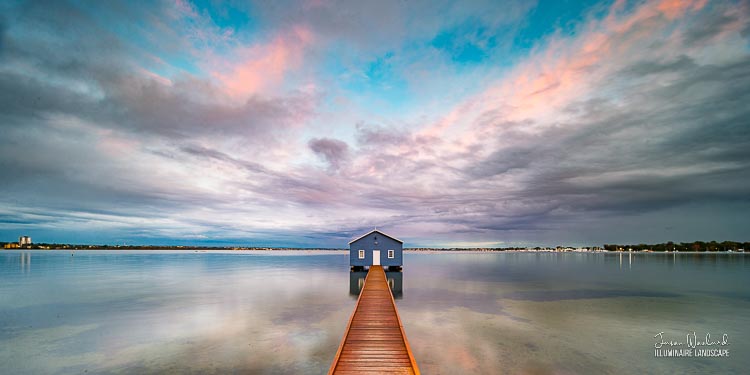Subtle apricots highlight the broken clouds at sunrise as the Blue Boat House reflects in the softly rippling water. Matilda Bay, Crawley, Western Australia, Australia - landscape photography