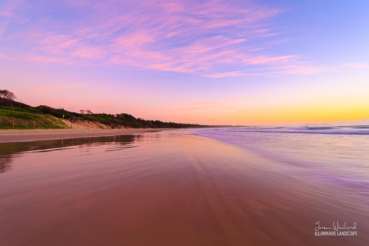 Sunrise over Broken Head Beach looking north to Cape Byron. The wet sand taking on the colours of the sky. Broken Head, NSW - landscape photography