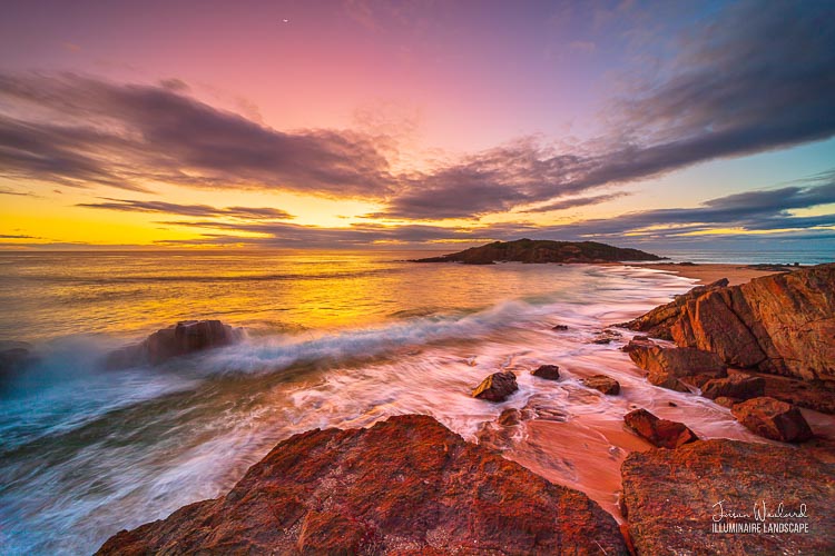 An incoming wave meets the outgoing wash under the gold, magenta and blue sky at sunrise. Bournda Beach, Sapphire Coast, NSW - Illuminaire Landscape